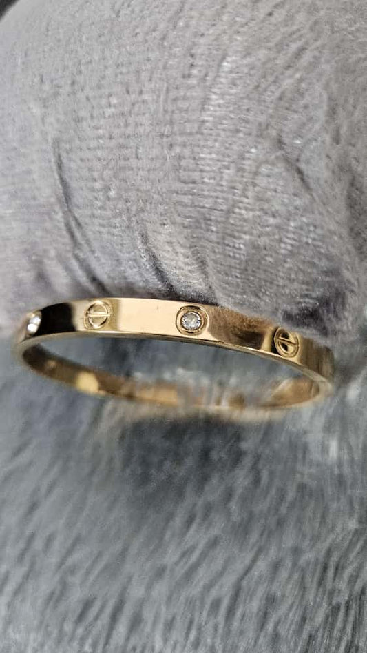 Elegant Screw Motif Gold-Finish Oval shaped Bangle with Stone Detailing